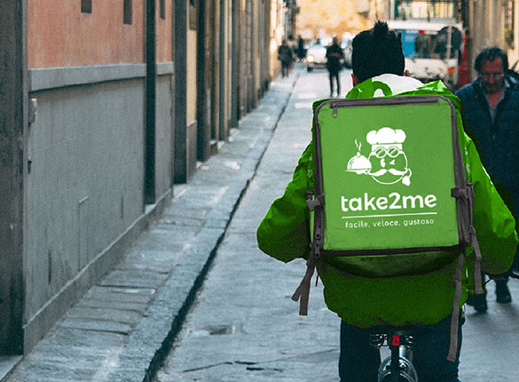 Driver in bici con la borsa di Take2Me.it per le consegne